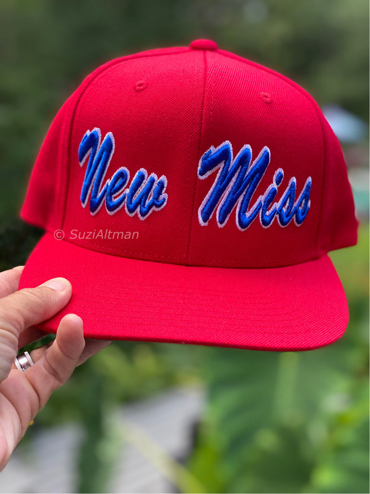 Bright red adjustable baseball cap with thick embroidery words in blue script New Miss